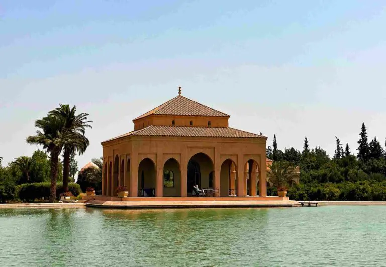 Musée marocain entouré d’eau avec une terrasse où quelqu’un est assis