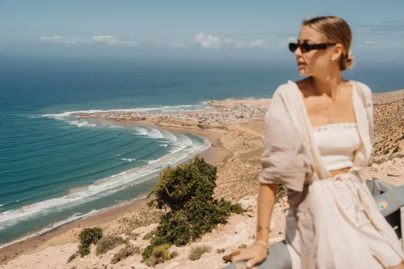 Femme qui pose devant une vue sur la mer