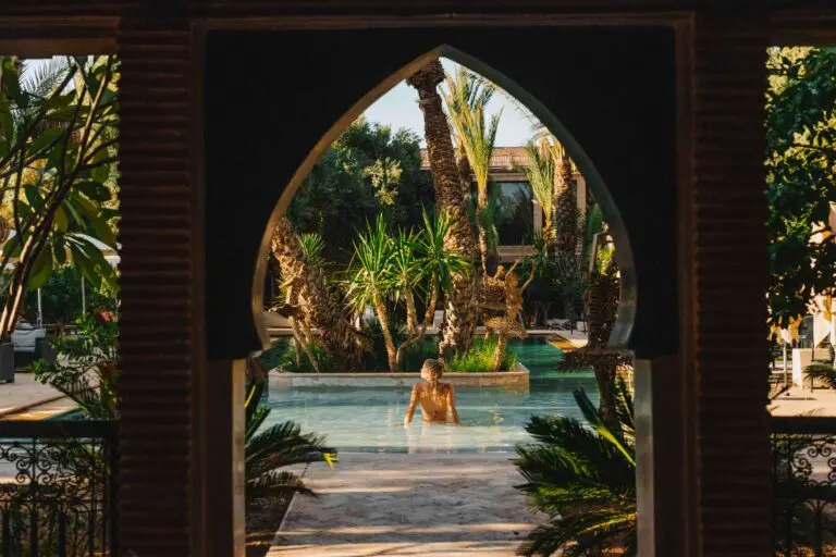Femme dans une piscine entourée de palmiers