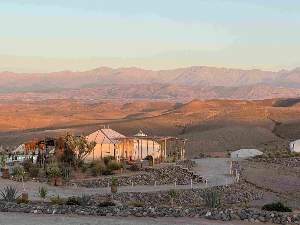 Vue sur un hôtel dans le désert d’Agafay avec les majestueuses montagnes de l’Atlas en arrière-plan