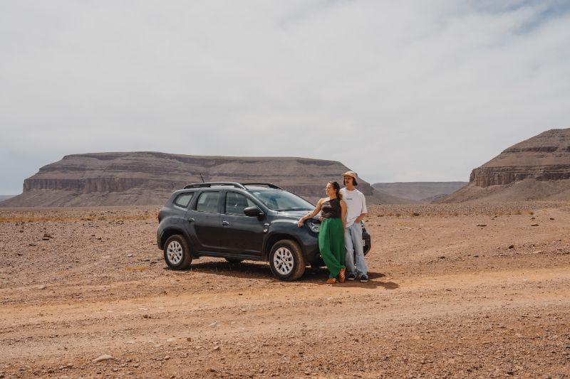 Couple devant une voiture dans le désert